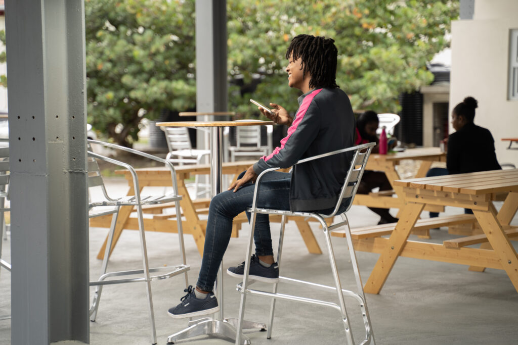 Image of itel's expanded Saint Lucia site. A staff member enjoying the open-air terrace and dining space that offers employees a chance to take in some fresh air in a safe, well-ventilated outdoor seating area.