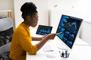 Image of an African-American woman analyzing data on her desktop computer