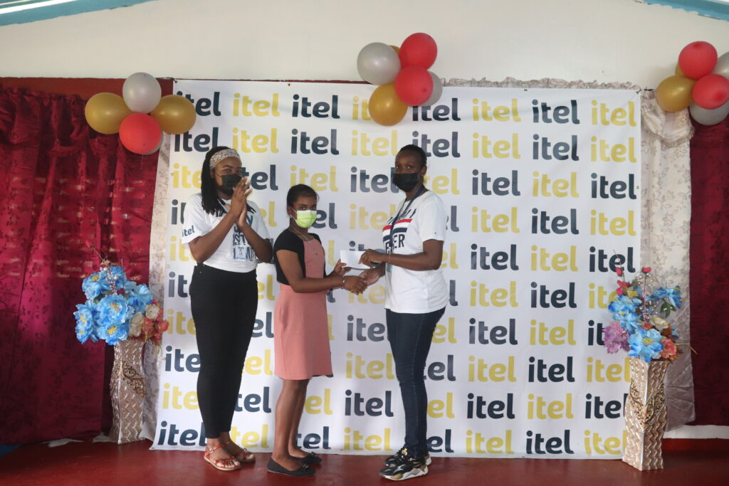 Image of itel representatives handing out one of two financial awards to high-achievers of Wakenaam's only primary school, in celebration of their exceptional test scores on Guyana’s Secondary School Entrance Examination (SSEE).