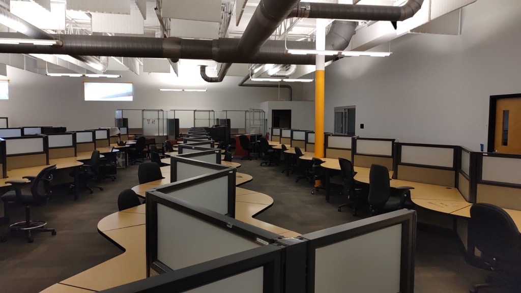 Inside image of itel's new Jeffersonville, Indiana customer experience center, which features a modern COVID-safe design that maintains a safe work environment for its contact center employees. Featuring a spacious production floor, with a desk and partition design that permits a 6-foot distance between agents and a separation between left and right sides.