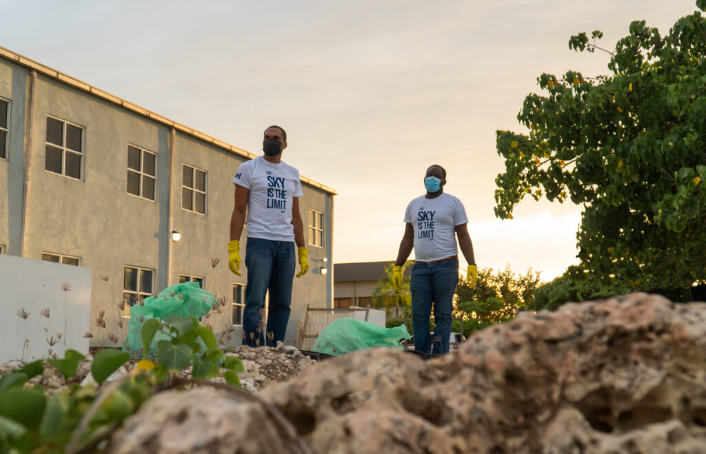 Sean Williams, itel's EVP of CX, joined by Yeashkark Allen, Group Director of EHSS, at itel's 2021 Jamaica Beach Cleanup, pitching in to remove litter and debris from the shoreline.